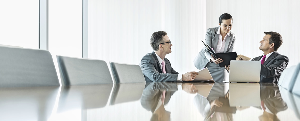 Two men and one woman meeting in a conference room