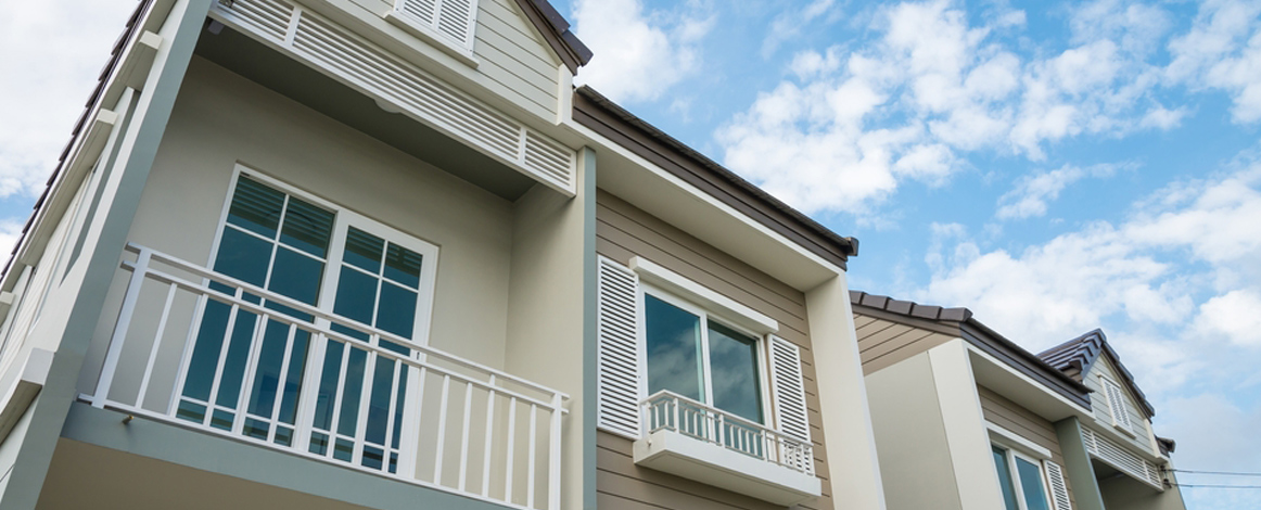 Front of house with blue sky and clouds above