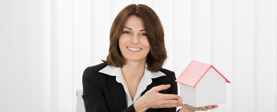 Woman holding model of property in hand