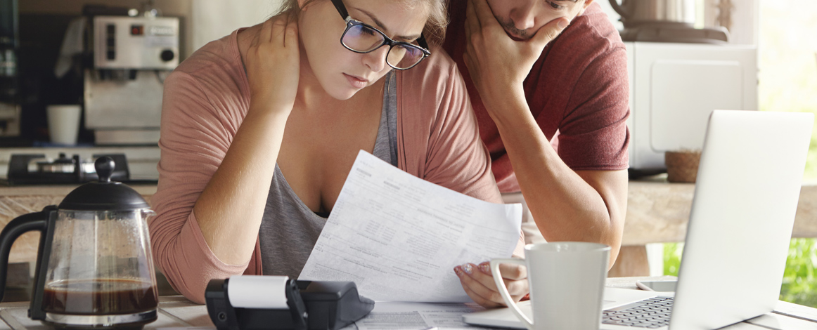 Woman and man looking at a document with calculator on desk