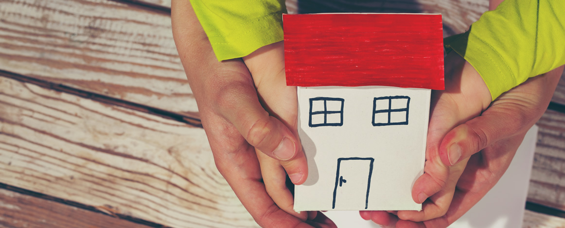 hands holding a paper house